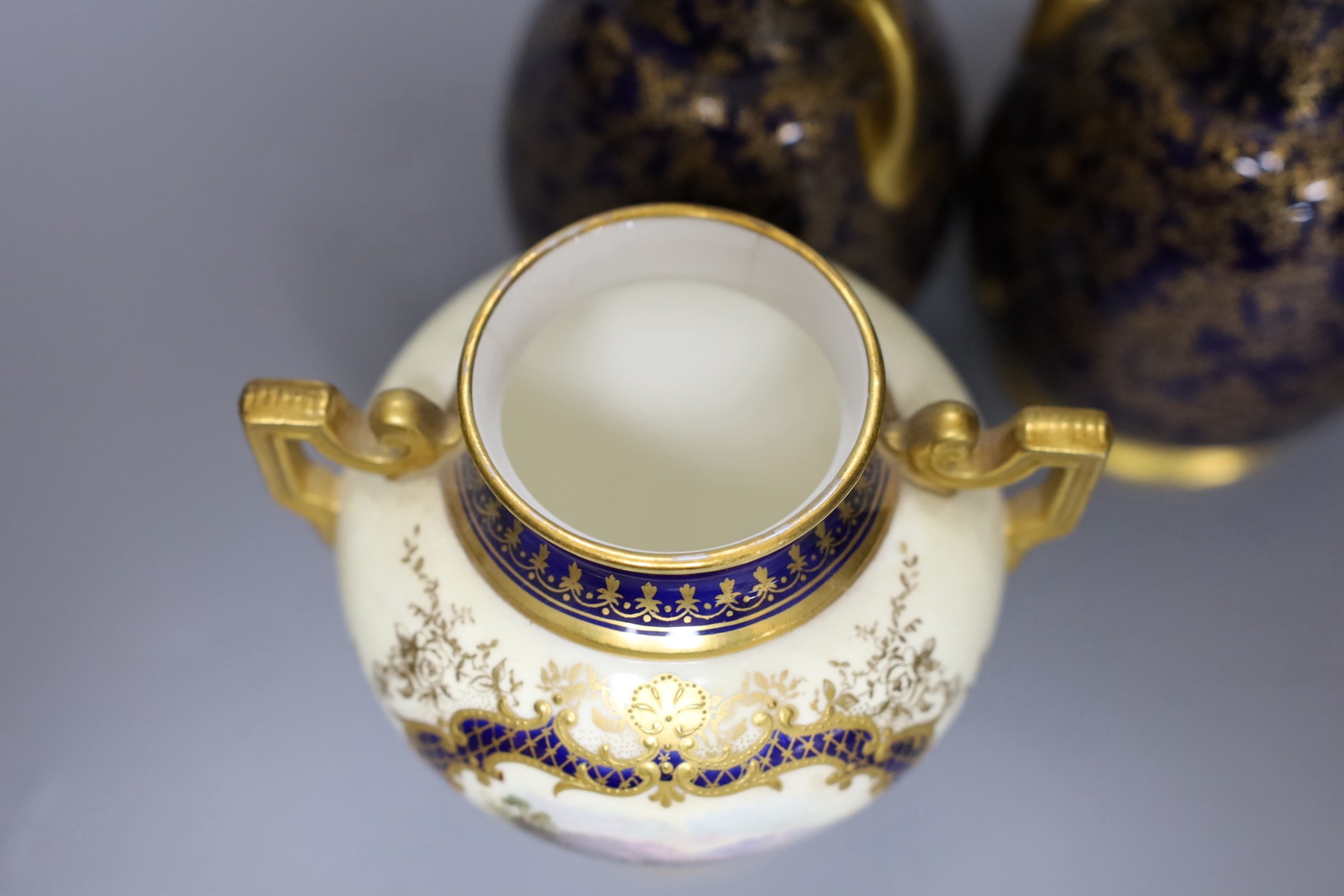 A pair of Royal Worcester bottle vases and a Coalport landscape vignette vase and cover, pair of vases 20 cms high